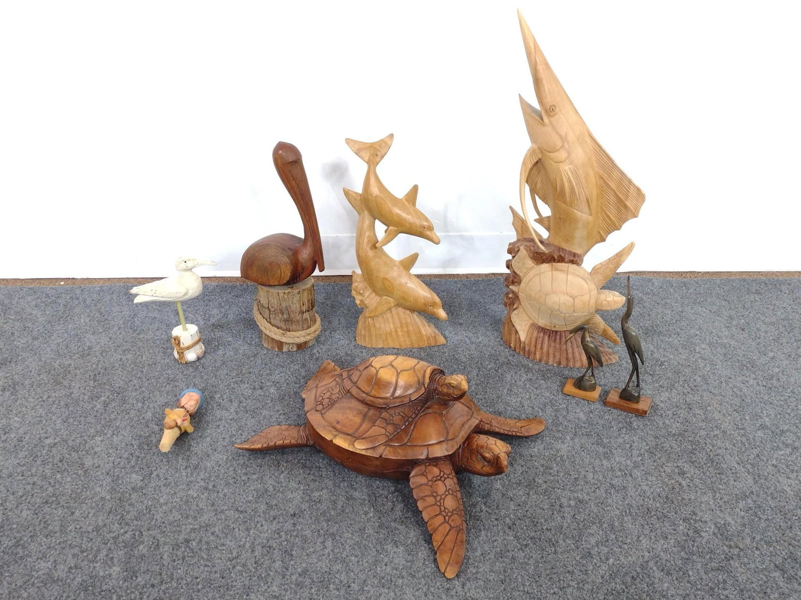 8 Hand Carved Nautical and Coastal Sculptures: Includes sea turtle with hatchling, marlin and sea turtle coral reef tower, leaping dolphins, pelican, shore bird, and novelty. 2-1/2" to 9-1/4" wide x 9-1/4" to 23-3/4" high. 