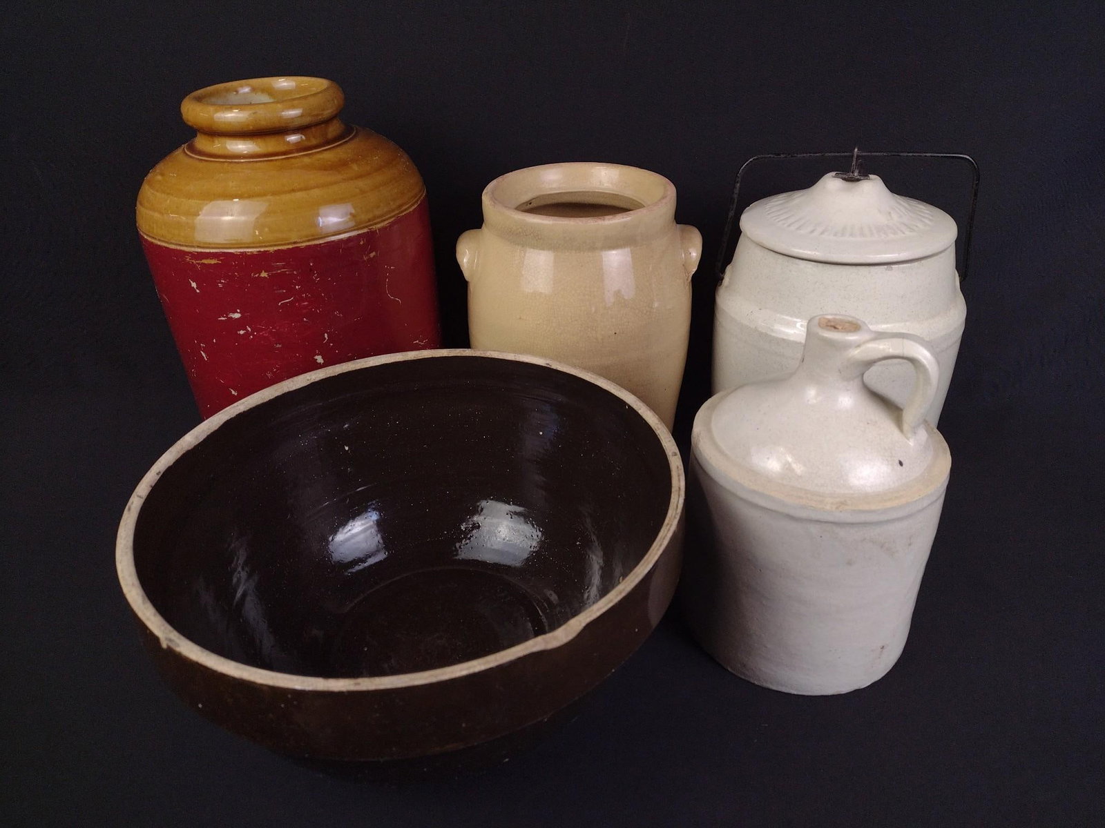 5 Pcs Stoneware and Yellowware: Includes crock, jugs, and bowl. 5-1/4" to 8-1/4" wide x 8-1/2" to 12-1/2" high. Brown bowl has a slight crack in the rim.