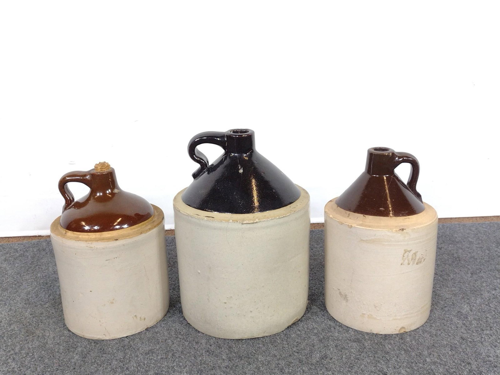 3 Stoneware Jugs: All unmarked. 7" to 9" wide x 10-1/2" to 12" high. 