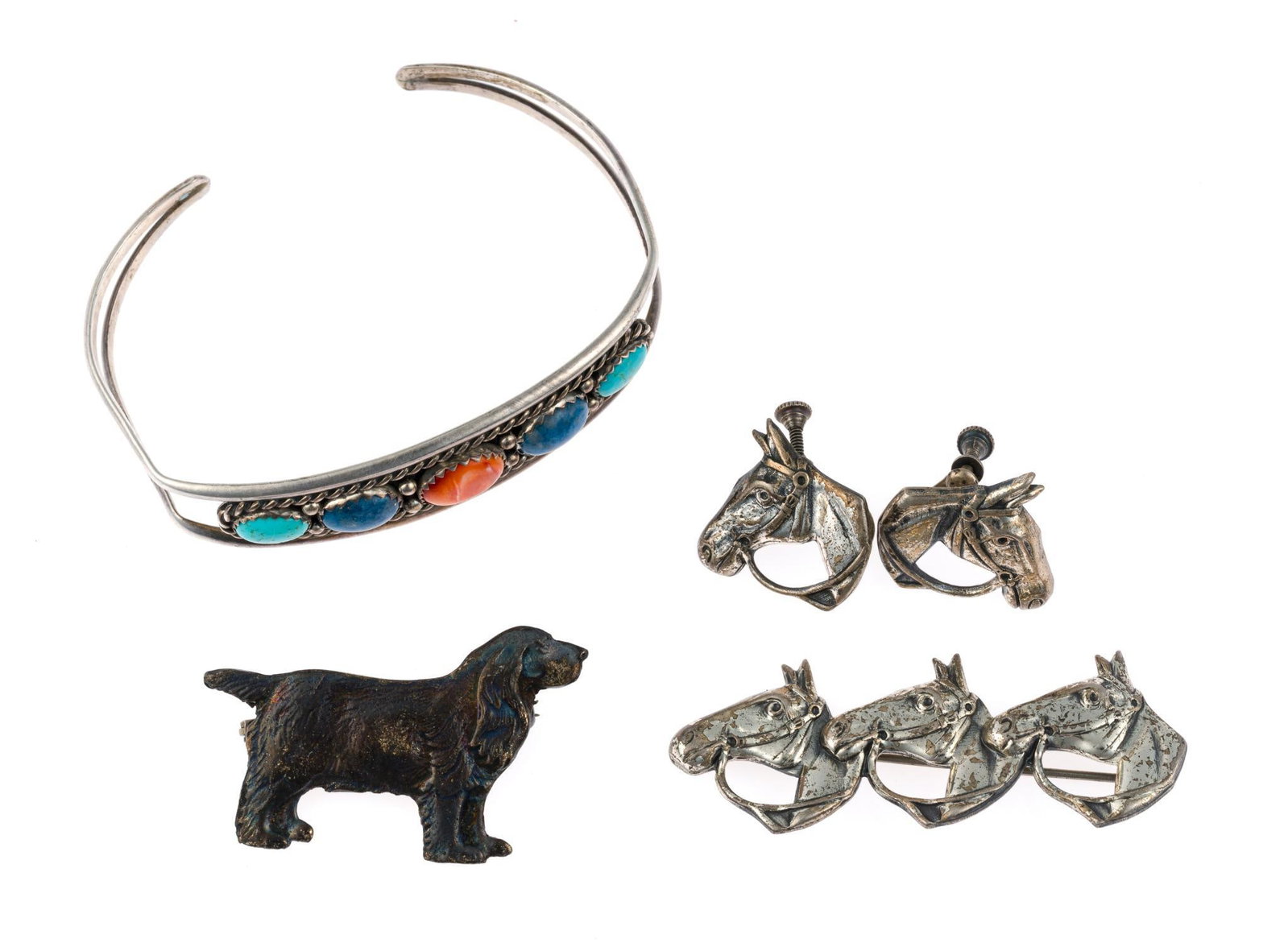 Sterling Silver Jewelry: All marked. Includes multi stone cuff bracelet with turquoise, lapis, and coral, two pins including dog and triple horse head, and pair of equestrian earrings. Cuff measures inside diameter
