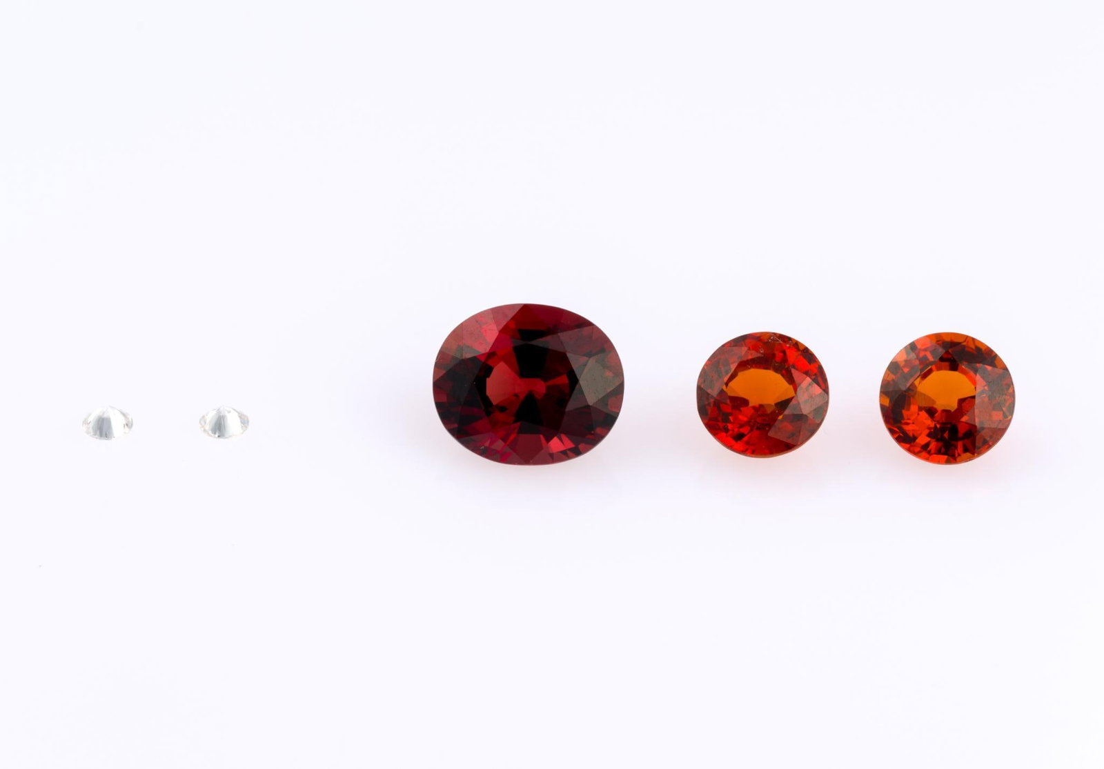 5 Loose Gemstones: Includes (2) .05 ct diamond, (2) round garnet, and oval synthetic spinel. 