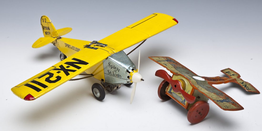 2 Charles Lindbergh Tin Litho Airplane Toys: DESCRIPTION: Two Charles Lindbergh related tin litho airplane toys. Includes: 1) J. Chein Spirit of America tin wind-up. Top with graphic of flight from New York to Paris. Tail marked "PNX 211". 6-1/2