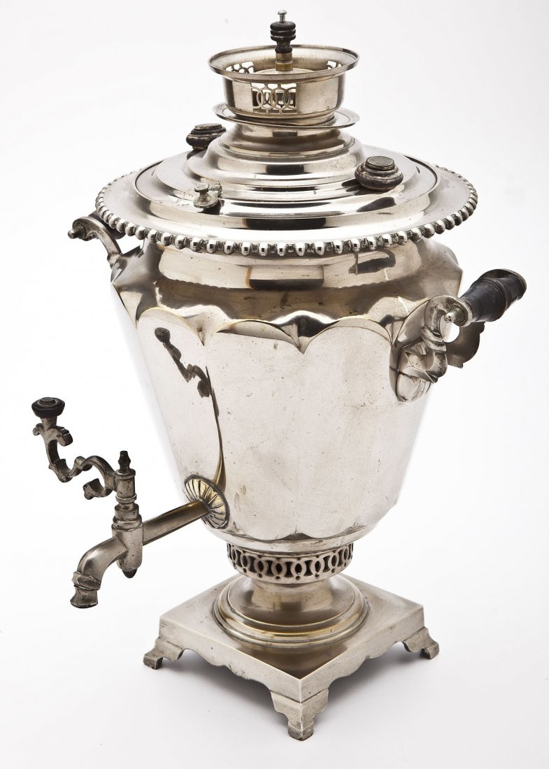 Russian Nickel Plated Samovar: DESCRIPTION: Russian nickel plated brass samovar. Ribbed conical shape with beaded top edge and two wood handles, the top with oval shaped makers mark, resting on a reticulated and footed base. MEASUR