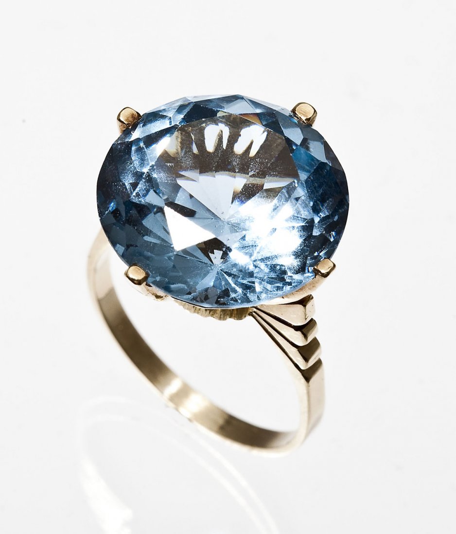 14K Blue Stone Cocktail Ring: DESCRIPTION: Cocktail ring in marked 14K yellow gold set with one 5/8" diameter synthetic blue spinel. The stone is held by four prongs atop a setting with scalloped open work. Size 7-1/2. 4.5 dwt. (7