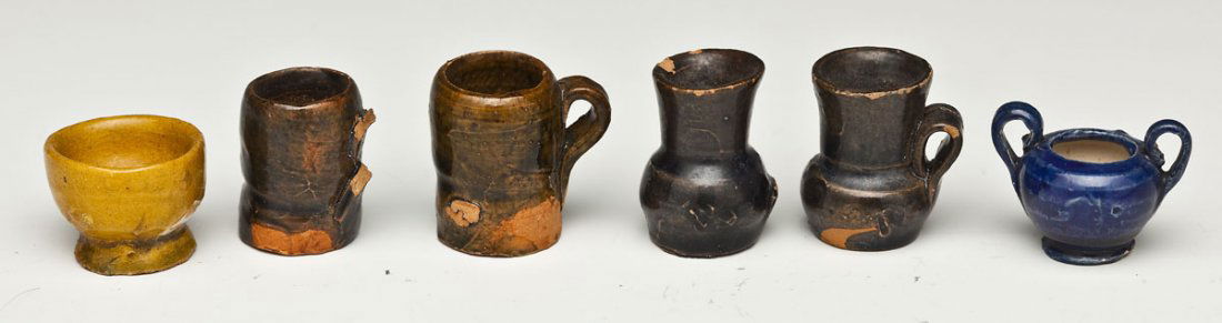 6 Redware & Yellowware Miniatures: DESCRIPTION: Six redware and yellowware miniatures. Includes four brown mugs, one yellow bowl, and one blue bowl with handles. 19th/20th century. MEASUREMENTS: Brown 3/4" to 1" high. Yellow 1/2" high.