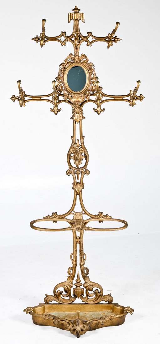 Victorian Cast Iron Hall Rack: DESCRIPTION: A Victorian cast iron hall rack, American circa 1880. The elaborate rococo revival cast rack consisting of a drip pan on the base with umbrella holder, hat rack and facing mirror. Eagle m