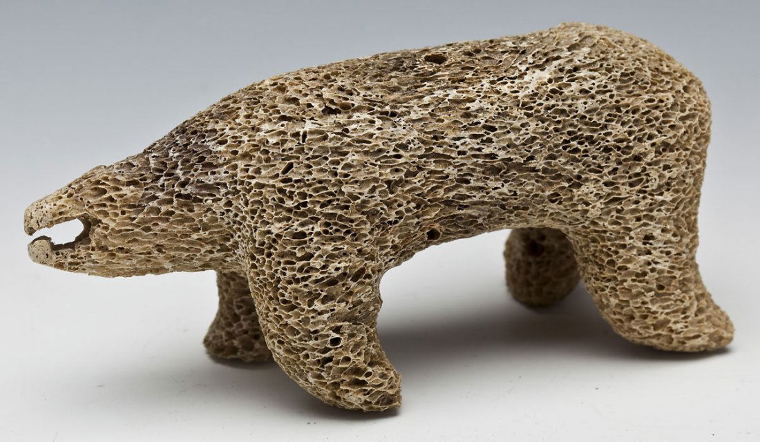 Intuit Petrified Whale Bone Polar Bear Sculpture: DESCRIPTION: Inuit carving of petrified whale bone portraying a polar bear. Unsigned. MEASUREMENTS: 6-1/4" x 2-3/4" x 2-3/4" high. CONDITION: No defects noted.