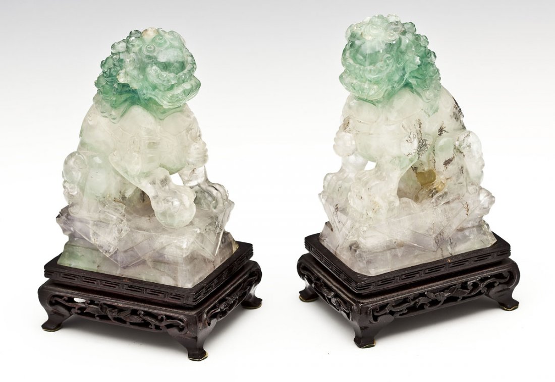 Pair of Chinese Carved Fluorite Foo Dogs: DESCRIPTION: Pair of Chinese carved fluorite foo dogs on plinthe bases and carved wood stands. MEASUREMENTS: Each 4-3/4" x 2" x 2-3/4" without base. CONDITION: Each with a few small nicks to florite. 