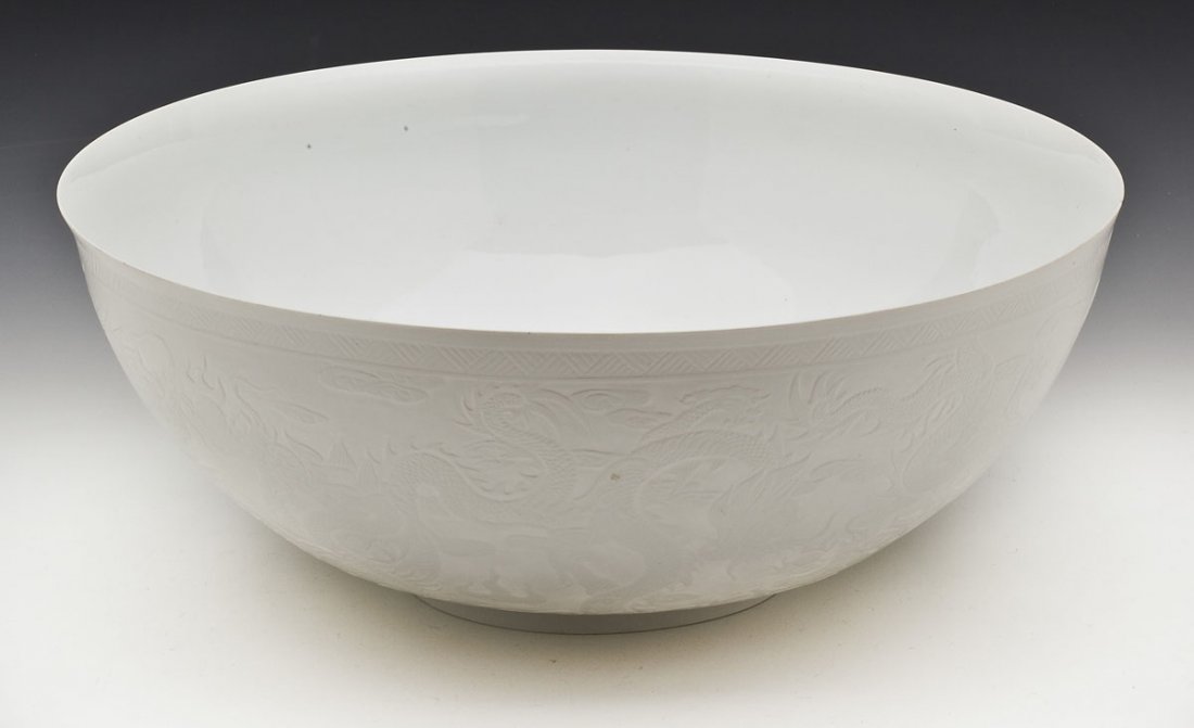 Chinese Jingdezhen Nine Dragon Eggshell Bowl: DESCRIPTION: A large white Chinese eggshell porcelain bowl, the exterior depicting nine dragons chasing pearls in relief. With Jingdezhen Zhi mark. 20th century. Housed in original box. MEASUREMENTS: 