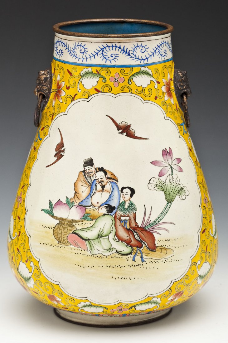 Chinese Enameled Copper Vase: DESCRIPTION: Chinese enameled copper vase with lion's head handles, decorated with two cartouches of figures and bats on a floral decorated yellow ground. Interior enameled in blue. Qianlong mark unde