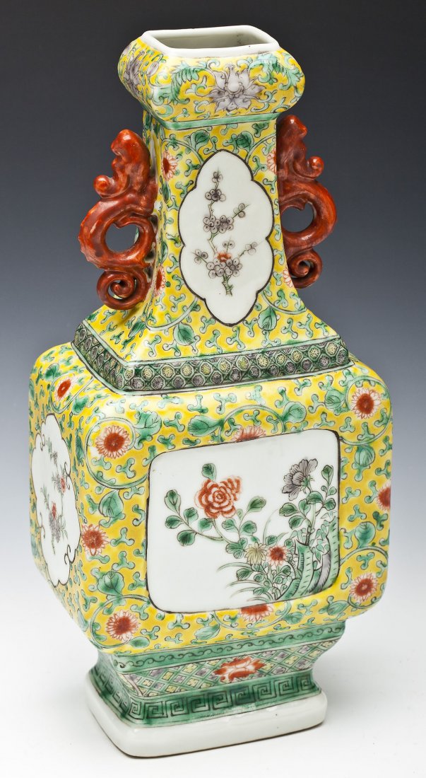 Chinese Famille Jaune Vase: DESCRIPTION: Chinese famille jaune vase with red figural dragon handles. White reserves depicting flowers and trees among a landscape of green vines and red flowers on a yellow background. Old label t