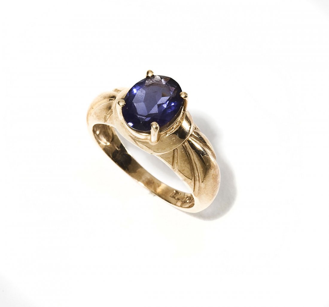 10K & Iolite Ring: DESCRIPTION: Marked 10K yellow gold ring set with one 9mm x 7mm oval faceted iolite. Size 7. 2.4 dwt (3.8 gr).