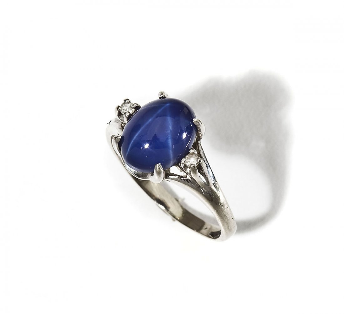 14K Diamond & Star Sapphire Ring: DESCRIPTION: Marked 14K white gold ring set with one oval synthetic blue star sapphire and two approximately .02 carat diamonds. Size 4-3/4. 1.8 dwt (2.7 gr).