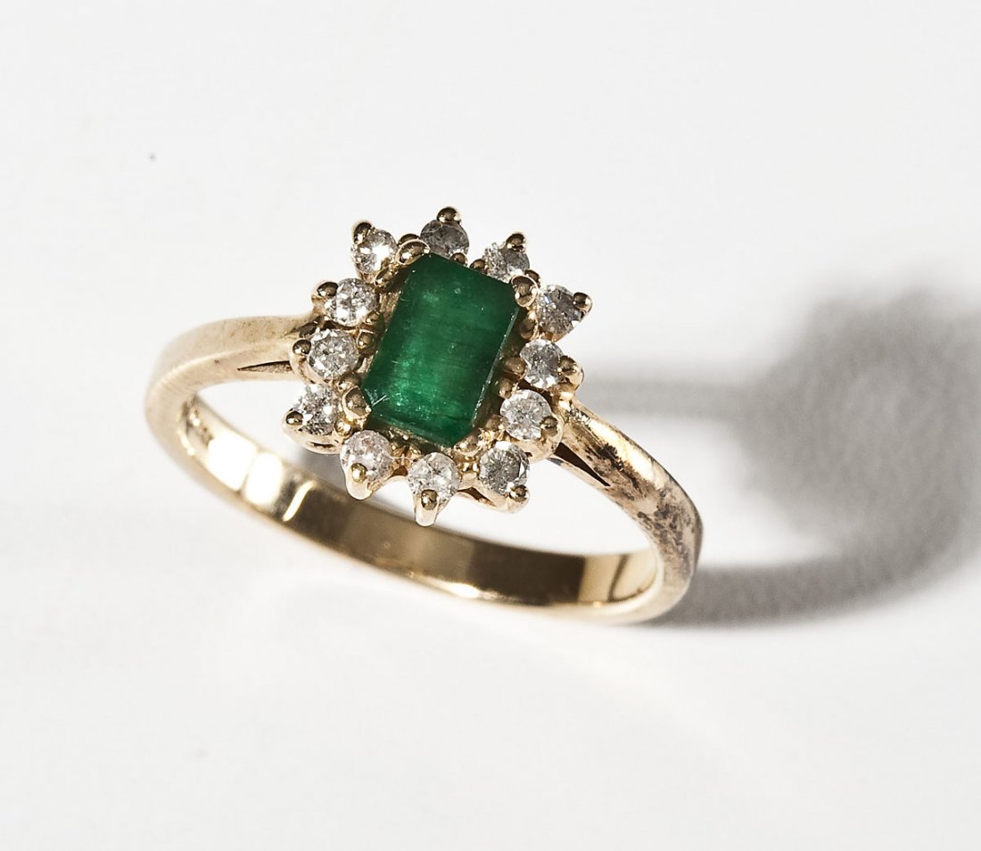 Emerald & Diamond Ring: DESCRIPTION: Marked 14K yellow gold ring set with one approximately 6mm x 4mm emerald cut genuine emerald and twelve approximately 3 point round diamond melee. Size 6-3/4. 2.6 dwt (3.1 gr).