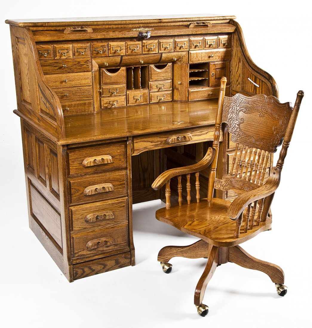 Oak Roll Top Desk & Chair: DESCRIPTION: Oak roll top desk with fitted interior. Base with drawers. Includes matching arm chair on wheels. MEASUREMENTS: Desk 54" x 33" x 50" high. Chair 20" x 17-1/2" seat x 39-1/2" high. CONDITI