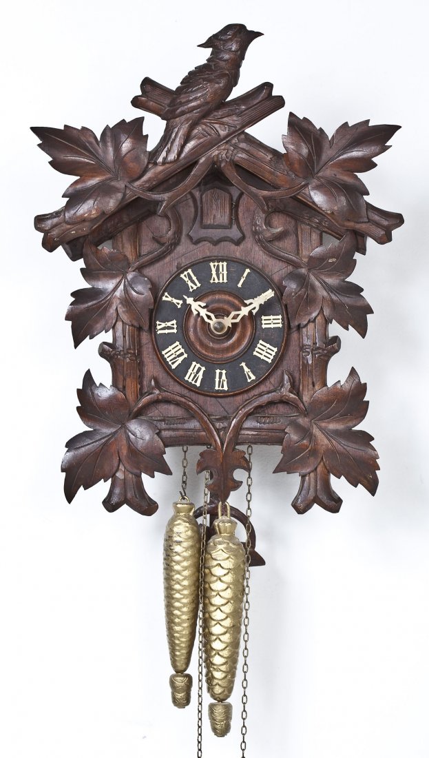 German Carved Wood Cuckoo Clock: DESCRIPTION: German carved wood cuckoo clock. Case decorated with birds and leaves in relief. Includes wood pendulum and gilded pinecone weights. Early to mid-20th century. MEASUREMENTS: Case 17-1/2" 