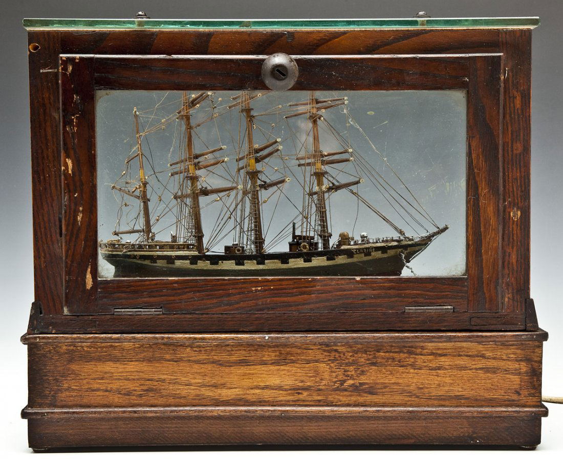Clipper Ship Lighted Display: DESCRIPTION: Lighted display of a clipper ship named "CLARINE". The ship is encased in a glass display with a front door which opens. The glass case sits on a wooden base encasing a vintage light and
