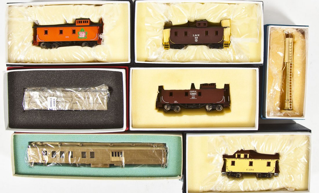 7 Brass Cars & Accessories incl PRR Box Car: DESCRIPTION: Seven assorted brass cars and accessories including four cabooses, PRR box car, combine, and sanding tower. HO scale. CONDITION: Appear unused in original boxes.