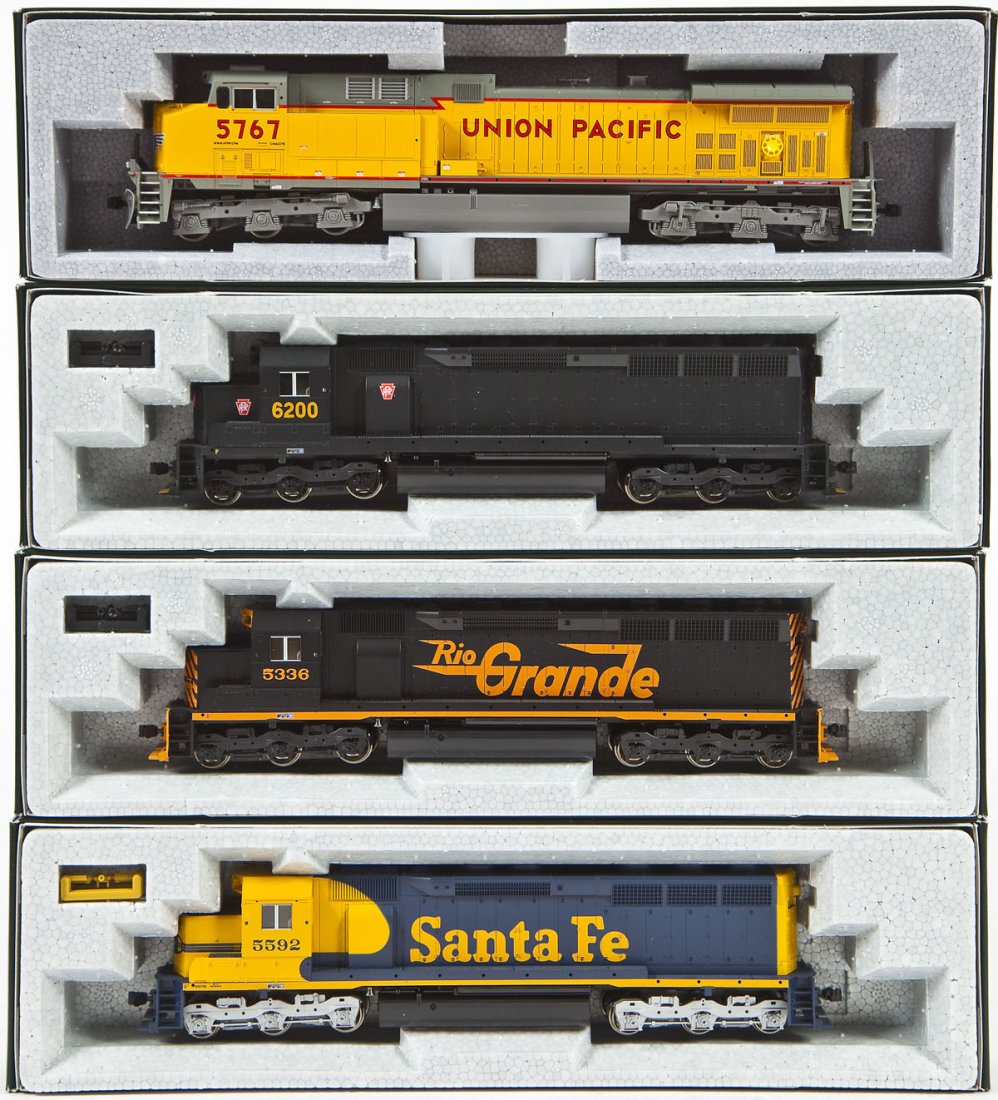 4 Kato HO Locomotives: DESCRIPTION: Four Kato locomotives including UP #5767, Rio Grande #5336, PA #6200, and SF #5592. HO scale. CONDITION: Appear unused in original boxes.