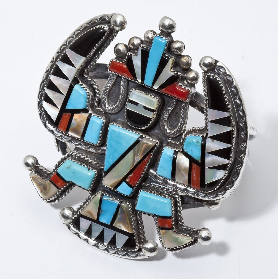 Large Signed Zuni Eagle Dancer Cuff Bracelet: DESCRIPTION: Large Zuni cuff bracelet in the form of an eagle dancer inlaid with various hardstones including turquoise, mother of pearl and onyx. Signed "JD". MEASUREMENTS: Top 3" x 3-3/8". Opening 2