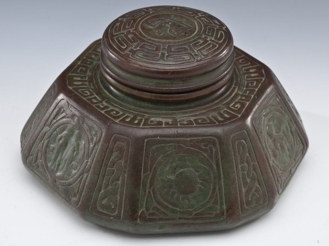 Tiffany Studios Bronze Zodiac Ink Well: DESCRIPTION: Tiffany Studios bronze Zodiac ink well. With glass liner. Marked on the bottom "Tiffany Studios New York 1072". Circa 1900. MEASUREMENTS: 6-1/2" x 6-1/4" x 3-1/2" high. CONDITION: Patina 
