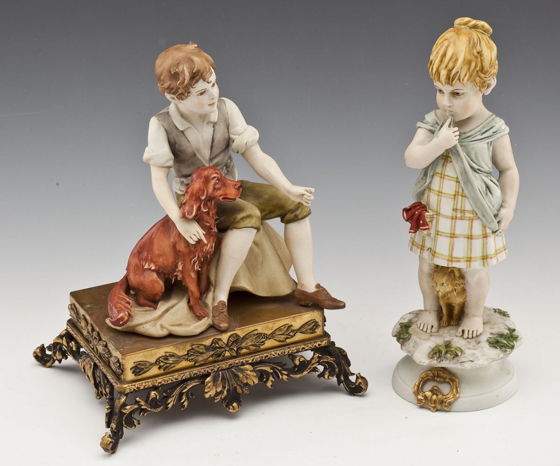 2 Triade Benacchio Porcelain Figurines: DESCRIPTION: Two Triade Benacchio porcelain figurines. Includes a boy seated with his dog seated next to him on a brass stand and a little girl with her finger to her mouth and her pet cat at her feet