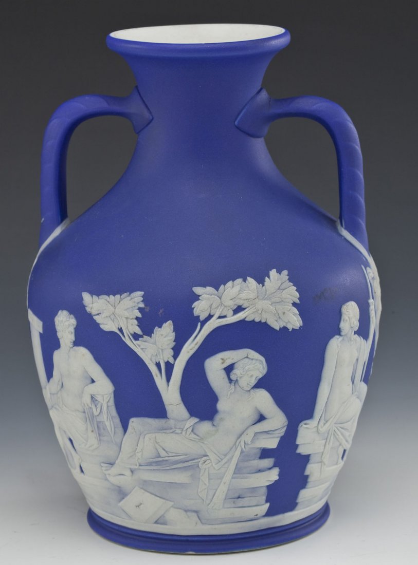 Wedgwood Blue Jasperware Portland Vase: DESCRIPTION: Wedgwood blue jasperware Portland vase. Baluster form with two handles and Classical scenes. Impressed "Wedgwood M" under base. MEASUREMENTS: 8" high. CONDITION: Very small inherent glaze