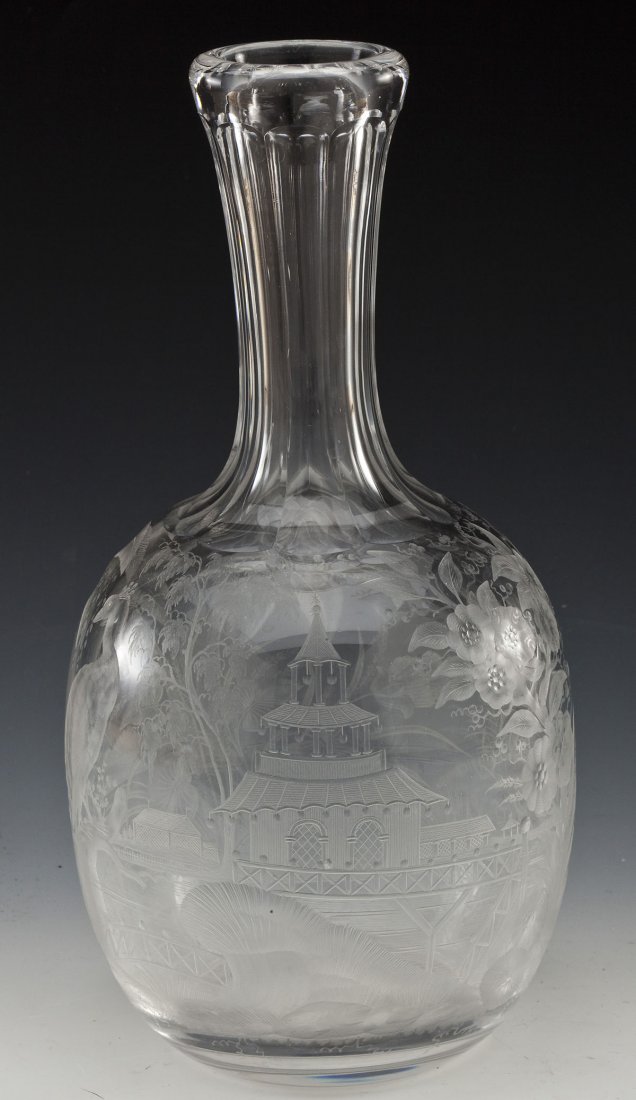 Intaglio Cut Glass Decanter: DESCRIPTION: Glass decanter intaglio cut with a landscape scene of a peacock, crane, palm trees and pagoda-form building. Late 19th century. MEASUREMENTS: 10" high. CONDITION: Light scratches under ba