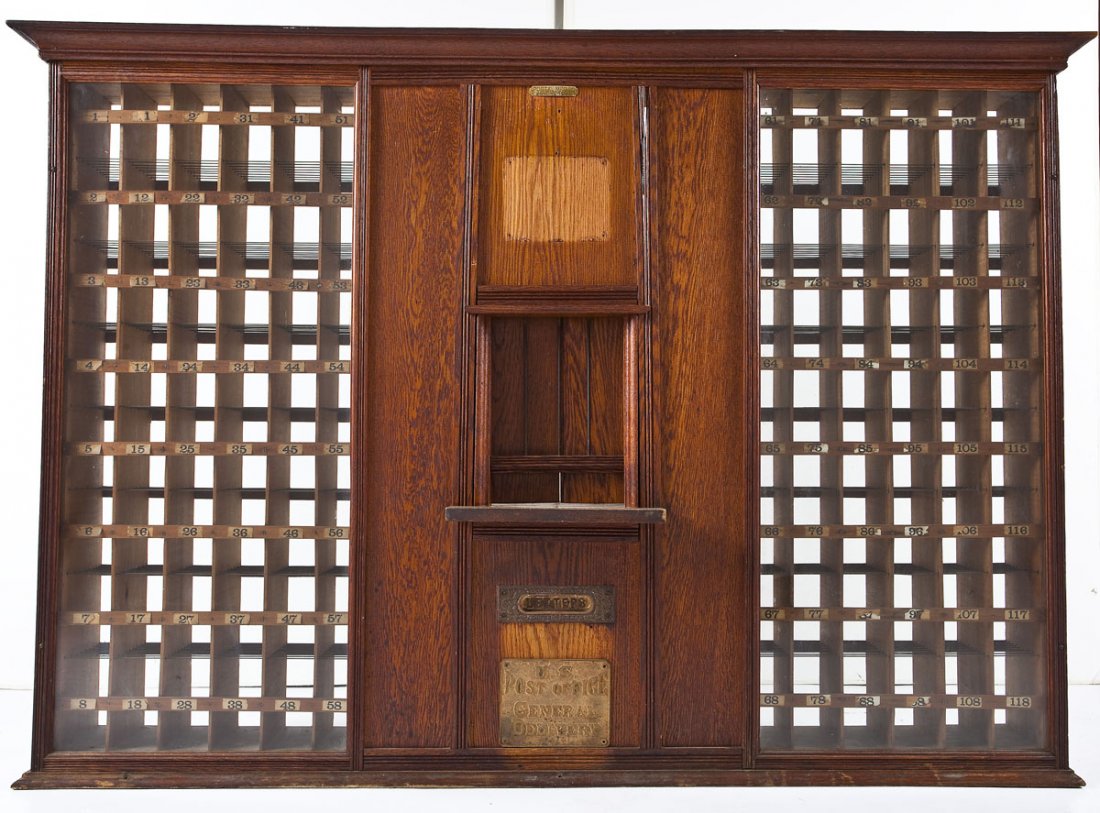 Baltimore Post Office Mail Cabinet: DESCRIPTION: A turn of the century (19th to 20th) oak post office facade consisting of 208 pigeonhole postal boxes surrounding a central stamp seller window and general delivery mail slot. The form co