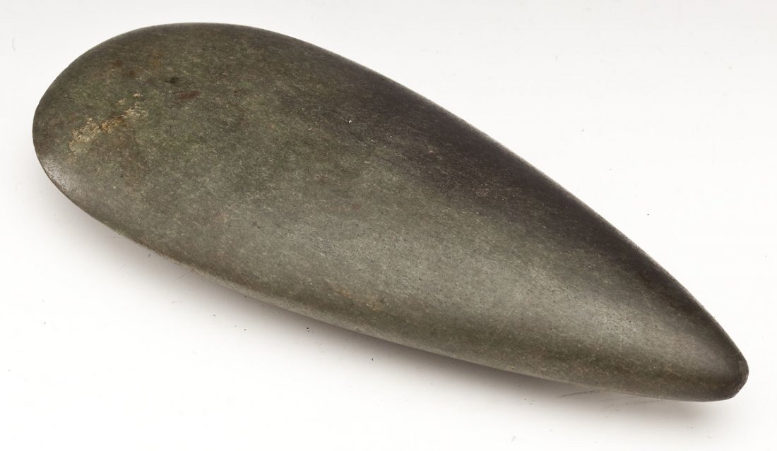 Taino Stone Axe: DESCRIPTION: Taino teardrop form green stone axe with fine polish patina. Circa 1000-1500 AD. PROVENANCE: From the estate of an Ohio collector. MEASUREMENTS: 7-3/4" long. CONDITION: 1/4" thin edge chi