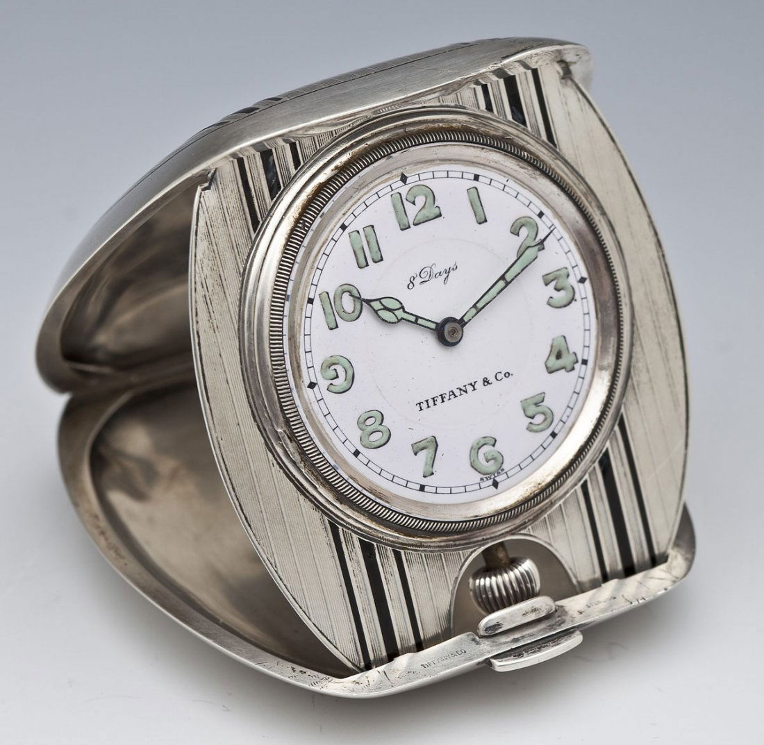 Tiffany & Co. Sterling 8 Day Travel Clock: DESCRIPTION: Tiffany & Co. sterling 8 days travel clock. Lid with black detailing and monogrammed "FW". Face reads "8 Days", "Tiffany & Co." and "Swiss". Numbers and hands painted with glow in the dar