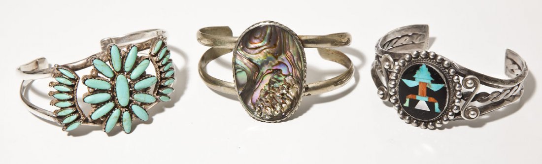 3 Native American Cuff Bracelets incl Zuni: DESCRIPTION: Three Native American cuff bracelets. Includes: 1) Silver bracelet set with large oval abalone stone. 1-1/2" wide at top. Opening 2-3/8" x 1-5/8". 2) Zuni cuff with thunderbird inlay in t
