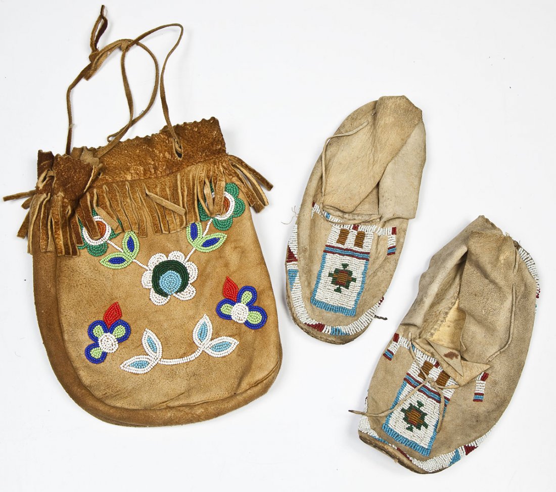 Plains Indians Beaded Moccasins & Bag: DESCRIPTION: Plains Indians polychromed beaded rawhide moccasins and bag. Moccasins with geometric beading and bag with floral beading and fringe. Early 20th century. MEASUREMENTS: Moccasins 9-1/2" lo