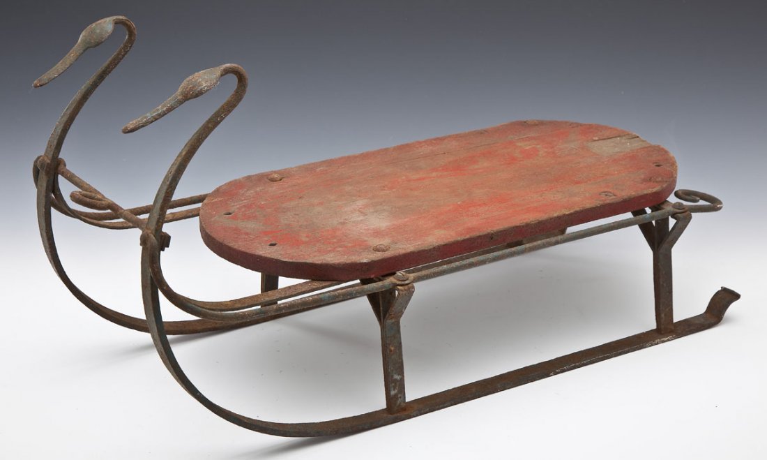Antique Wrought Iron & Painted Sled: DESCRIPTION: Child's sled with wrought iron frame and fancy runners. Wood top painted red with blue underneath. 19th century. MEASUREMENTS: 28" x 11-1/2" x 14-1/2" high. CONDITION: Overall patina and 