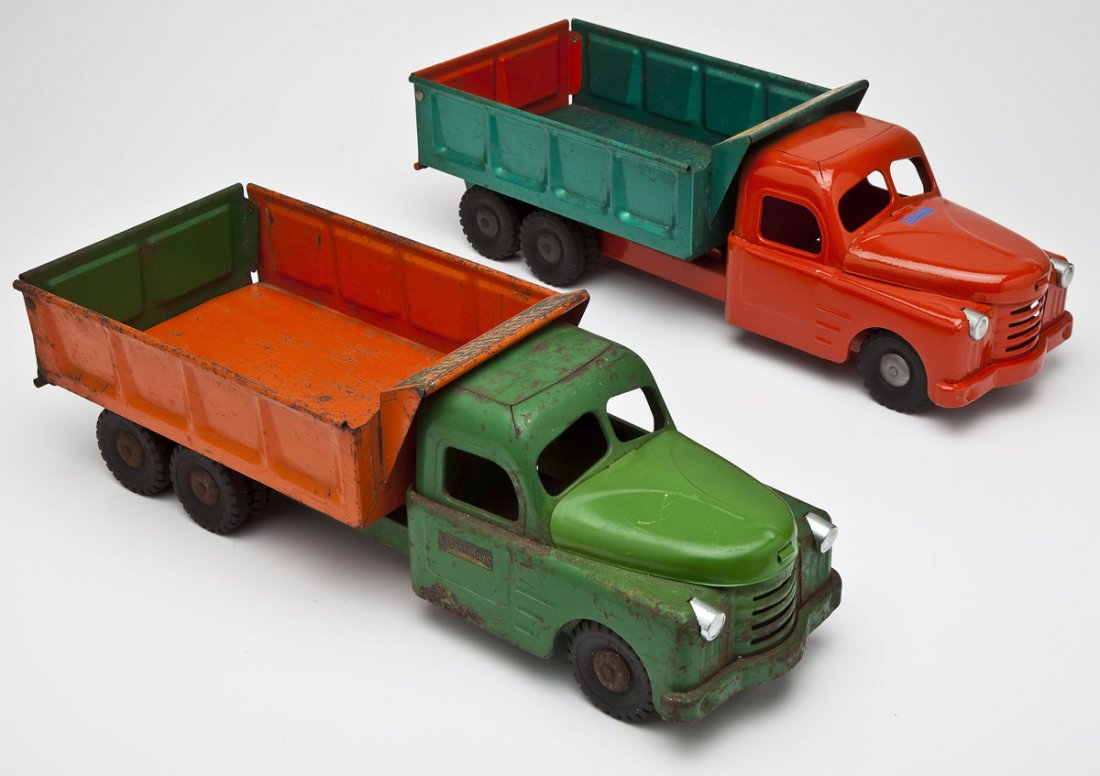 2 Structo Dump Trucks: DESCRIPTION: Two Structo dump trucks: 1) Green cab with orange dump. Hydraulic operated. 2). Orange cab with green dump. Hydraulic operated. MEASUREMENTS: Both 21". CONDITION: 1) Unrestored. Hydraulic
