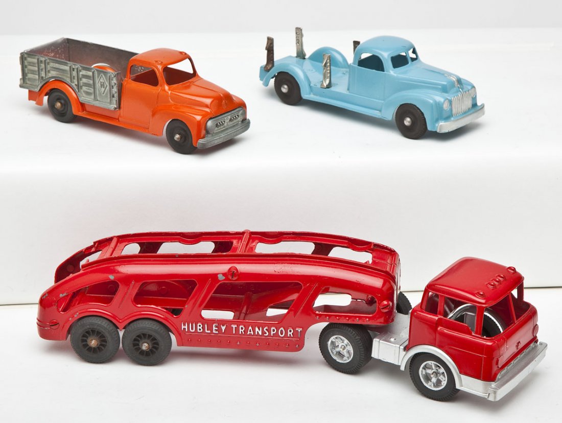3 Hubley Kiddie Toy Trucks Incl Transport: DESCRIPTION: Three Hubley kiddie toy trucks including Hubley Transport and two stake trucks. MEASUREMENTS: Each 7-13". CONDITION: All restored.
