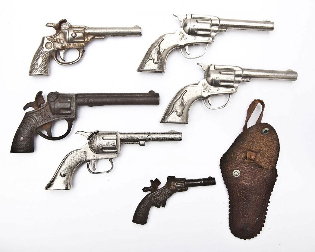 6 Cap Guns: DESCRIPTION: Six cap guns including Buddy and Cowboy cast iron, two Hubley, one Dik, and Halco. MEASUREMENTS: Each 3-1/2-6". CONDITION: Light wear.