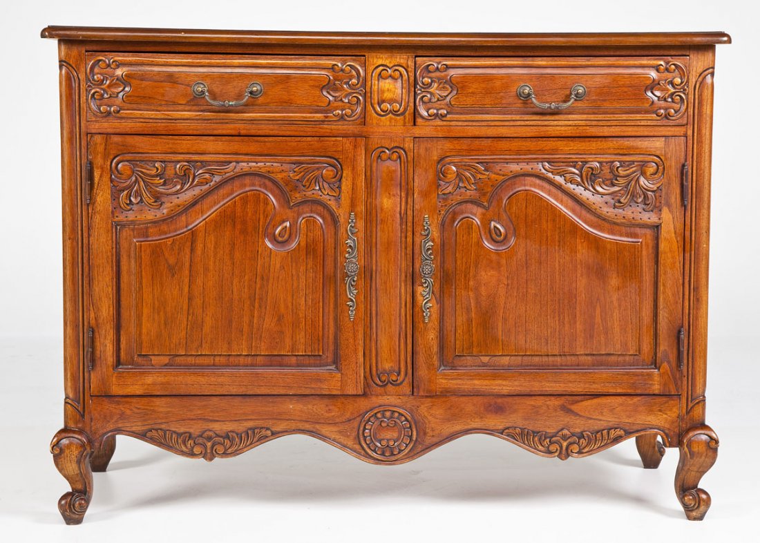 A French Louis XV Revival Sideboard: DESCRIPTION: A French Louis XV Revival sideboard consisting of two highly carved drawers over two equally highly carved doors all set into a carved case and resting on French rococo feet. 20th century