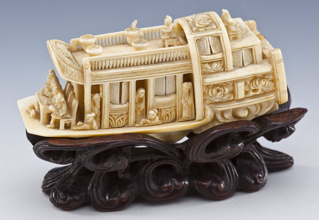 Carved Ivory Wedding Barge: DESCRIPTION: Carved ivory wedding barge. Articulated shutters open to reveal passengers. On wood base. MEASUREMENT: 4-1/2" long x 2-1/4" high x 1-3/4" wide without base. CONDITION: Two banners, two la