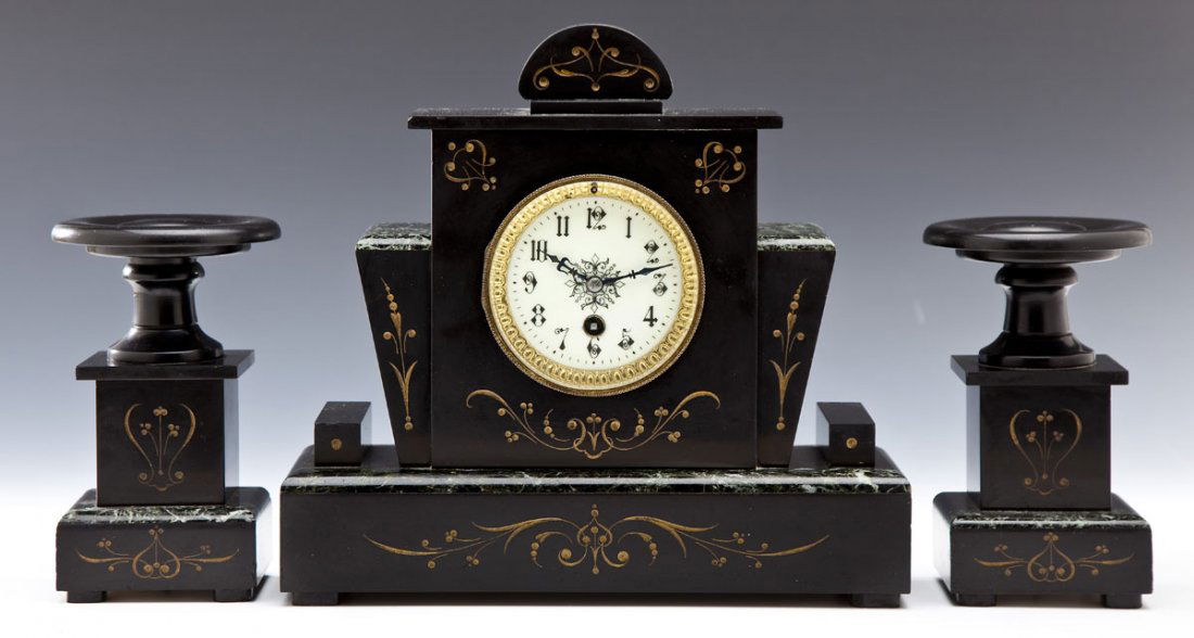Victorian Marble & Slate Garniture Set: DESCRIPTION: Victorian marble and slate garniture set. Black slate mantle clock with green marble accents with scroll decorations throughout. White enamel face with Arabic numerals. Two candelabras wi