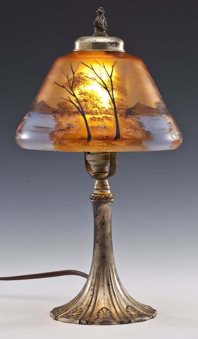 Lamp with Hand Painted Shade: DESCRIPTION: Lamp with hand painted orange shade. Shade painted with landscape of trees, streams, and mountains. Base with gilded brass and shell motif. Unmarked. MEASUREMENTS: 8" diameter x 14" high.