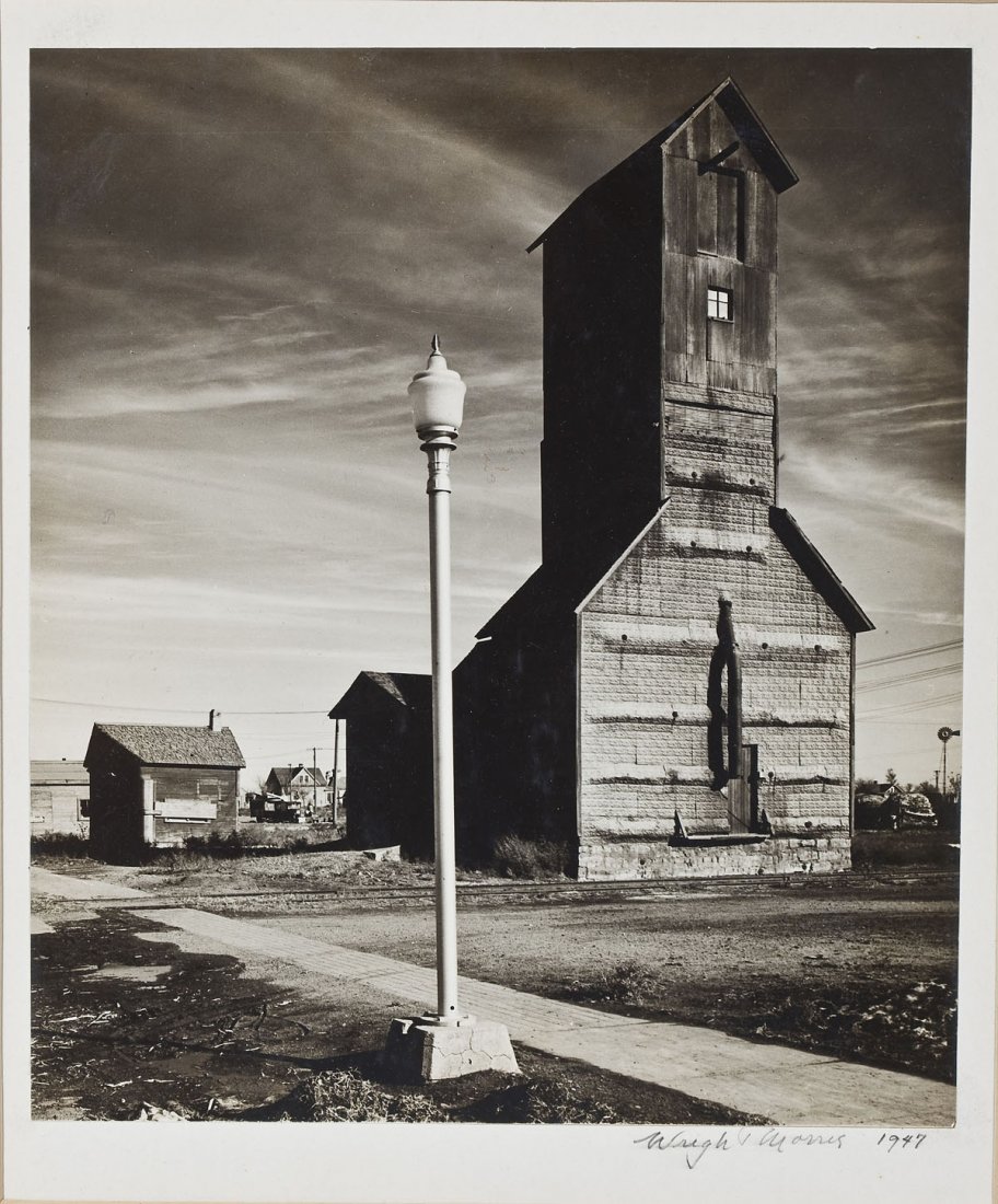 Wright Morris (American, 1910-1998): DESCRIPTION: Wright Morris (American, 1910-1998). Gelatin silver photograph. Grain Elevator and Lamp Post, Nebraska. Signed and dated in pencil along lower margin "Wright Morris 1947". Mounted on Cres