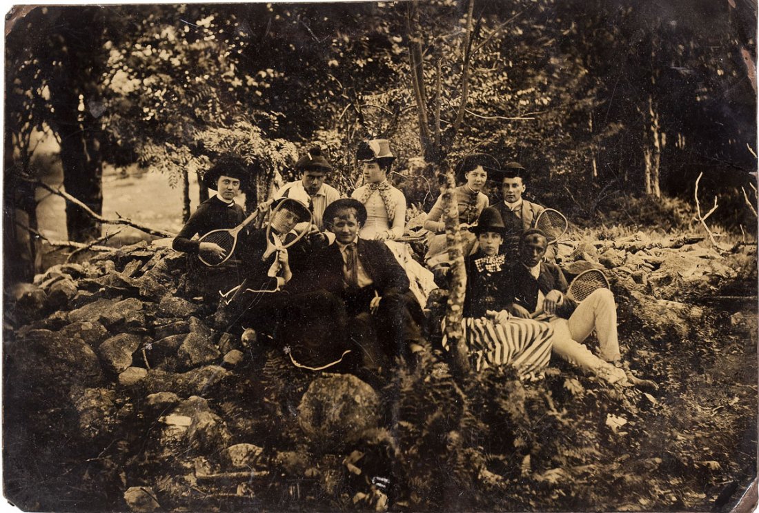 Large Full Plate Tintype of Tennis Party: DESCRIPTION: A large full plate tintype showing a group of men and women sitting on rocks amongst trees holding tennis rackets. MEASUREMENTS: 9-1/8" x 6-1/4". CONDITION: Light bends most noticeable to