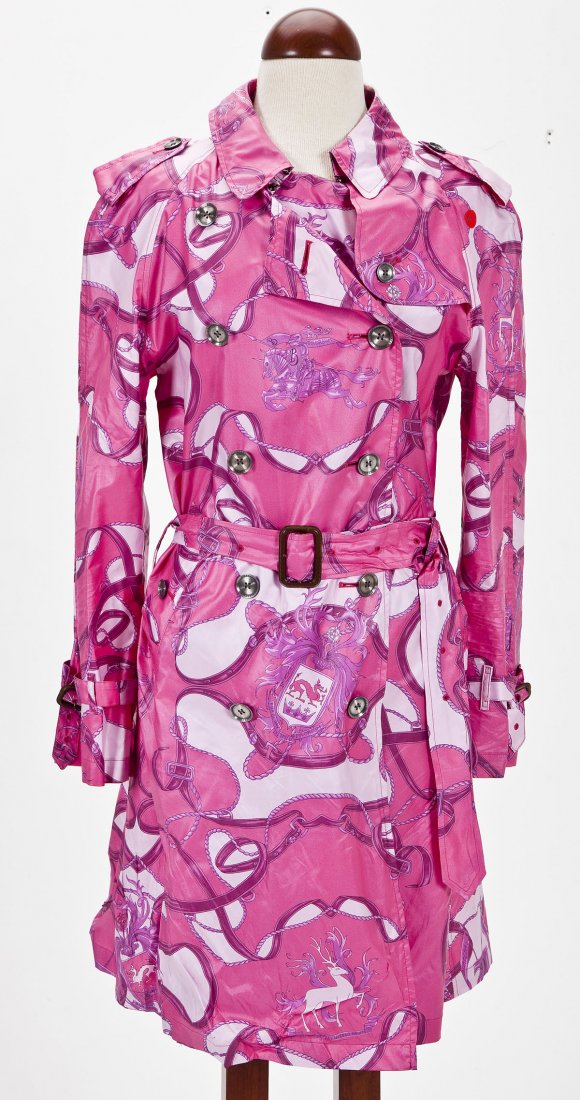 Burberry Pink Rain Coat: DESCRIPTION: Pink double-breasted rain coat by Burberry with pattern of ribbons, cords, unicorns, and crests. Metallic buttons and adjustable cuffs. Made in England. MEASUREMENTS: UK size 42. CONDITIO