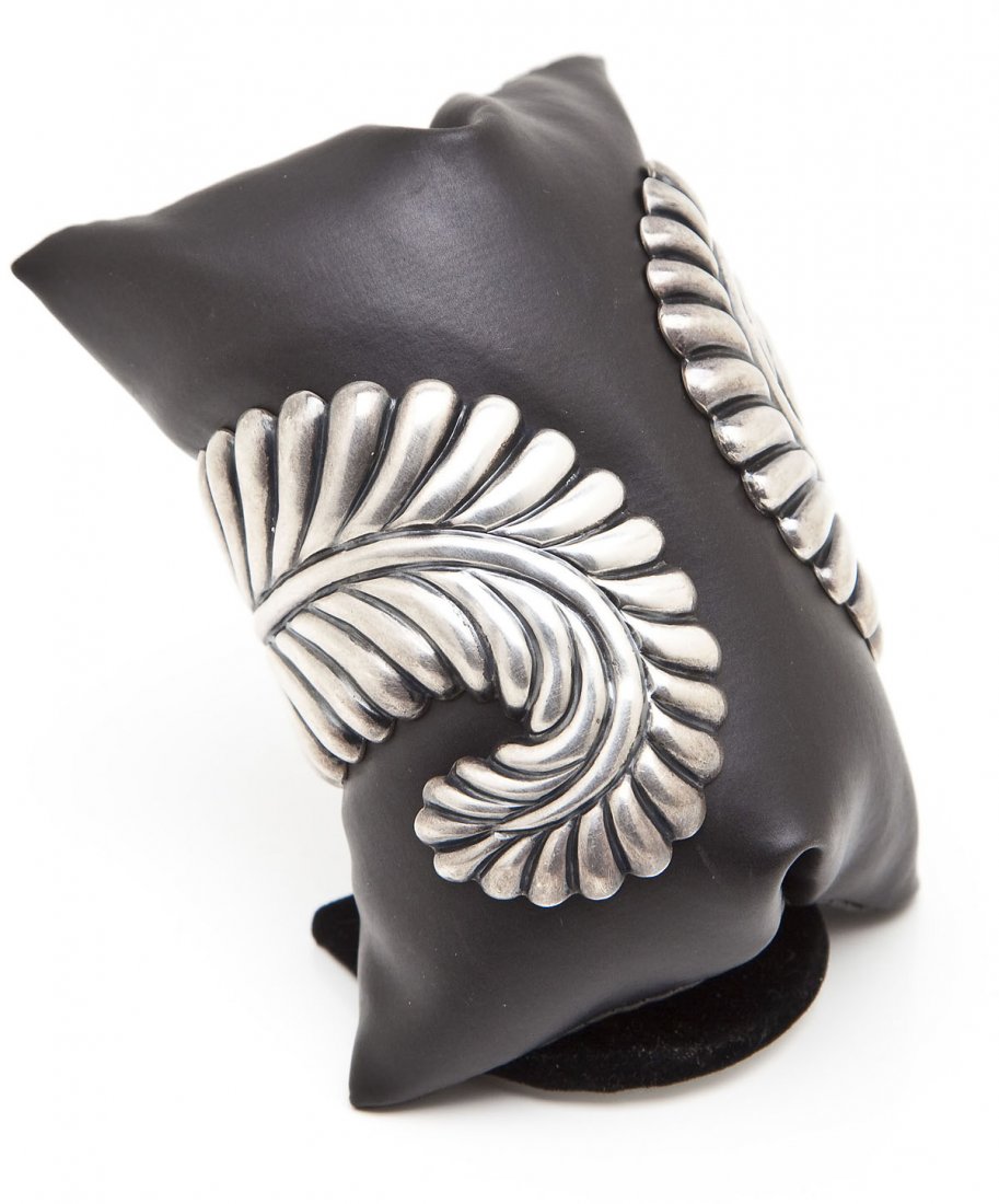 Los Castillo Sterling Fern Clamper Bracelet: DESCRIPTION: Mexican Taxco sterling hinged clamper bracelet with ribbed fern decoration. Signed "L.C." meaning Los Castillo. MEASUREMENTS: 3-3/8" wide at top. CONDITION: Minor wear.