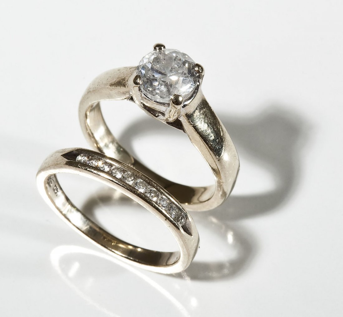 1.25 CTW Diamond Wedding Set: DESCRIPTION: Marked 14K white gold wedding ring set. Engagement ring set with one 1.15 carat round brilliant cut diamond. Clarity I2, color J. Channel set wedding band set with ten round .01 carat rou