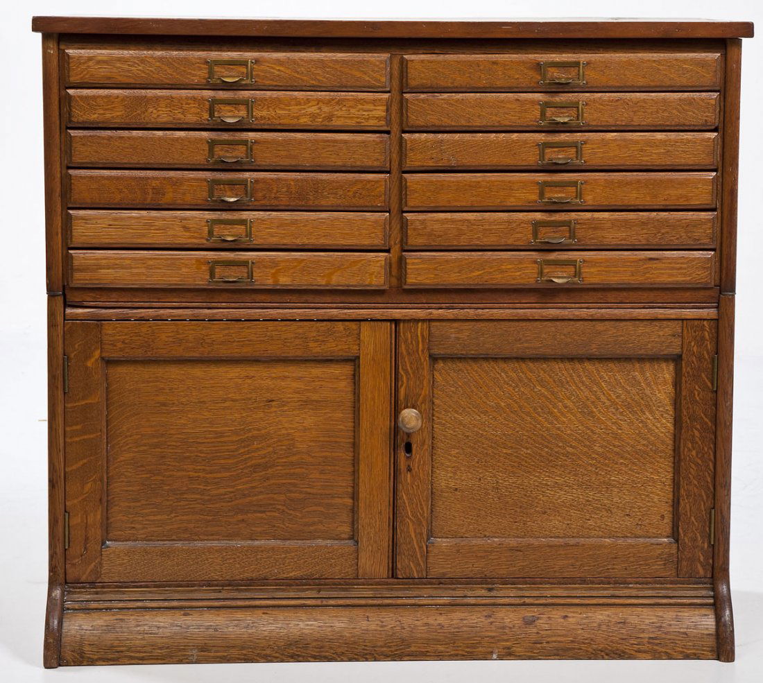 Oak Sectional Cabinet: DESCRIPTION: Two part oak sectional office cabinet. Twelve drawers over two doors. Circa 1900. MEASUREMENTS: 35" x 12" x 32" high. CONDITION: Wear consistent with age. Wood pull added.
