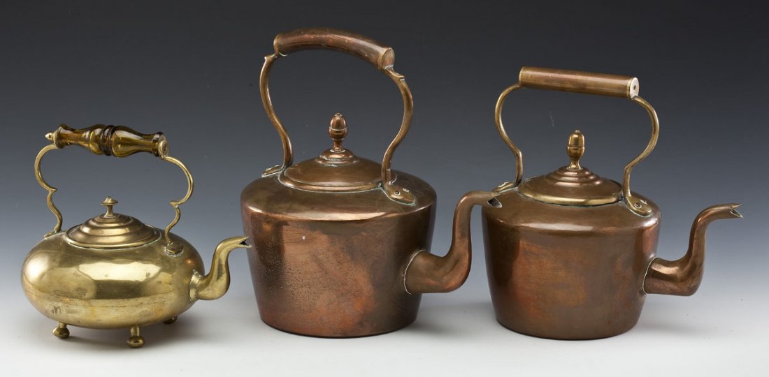 3 Early Kettles Copper & Brass: DESCRIPTION: Three antique kettles. Two copper and one brass kettle. Brass kettle with four feet and amber glass handle. MEASUREMENTS: Various. Range from 8" high to 11-1/2" high. CONDITION: Surface w