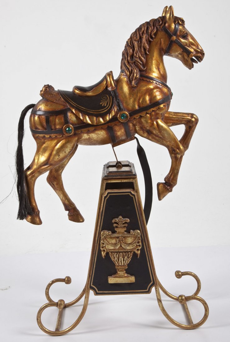 Modern Kinetic Rocking Horse: DESCRIPTION: A modern kinetic rocking horse of lightweight gilded and black painted wood with green "jewels" and horse hair tail. On a matching gilded wood and metal stand. MEASUREMENTS: 39" high. CON
