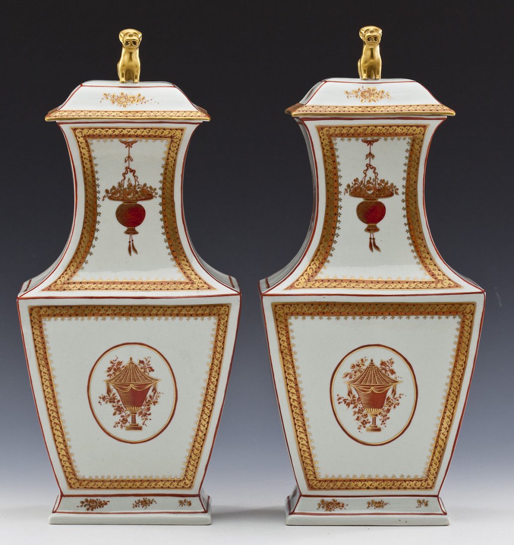 Pair of Mottahedeh Covered Urns: DESCRIPTION: Pair of Mottahedeh covered urns with iron-red and gold handpainted gilded design. Each with dog finial on lid. MEASUREMENTS: 11" base. 13-1/2" to top of finial. CONDITION: No defects note